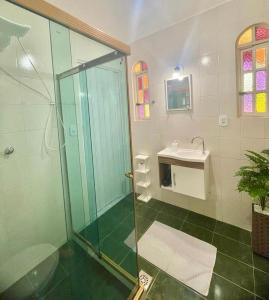 a bathroom with a glass shower and a sink at Mirante do Lago - Suíte Gold em frente ao Lago de Javary in Miguel Pereira