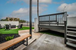 a patio with a wooden bench and a yard at Luxury on Ocean Drive - Sleeps 28 in Corpus Christi