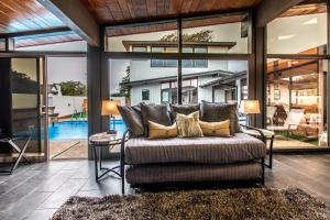 Una sala de estar con un sofá y grandes ventanales. en Luxury on Ocean Drive - Sleeps 28, en Corpus Christi