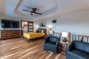 Un dormitorio con una cama, un sofá y un televisor. en Luxury on Ocean Drive - Sleeps 28, en Corpus Christi
