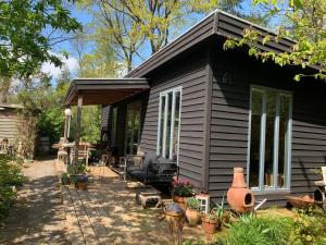 a black tiny house with a patio at Cabin Dakota in Ermelo