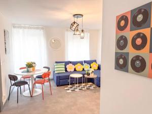 Una sala de estar con un sofá azul y una mesa. en Le JOY, centre ville, en Mulhouse