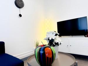 Una sala de estar con un jarrón con flores sobre una mesa. en Le JOY, centre ville, en Mulhouse 30 fotos más