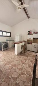 a large kitchen with a table and a ceiling fan at Casa Recanto in Trancoso