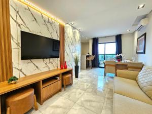 - un salon avec une télévision, un canapé et une table dans l'établissement Centro 2 quartos 2 banheiros - alto padrao novo, à Foz do Iguaçu