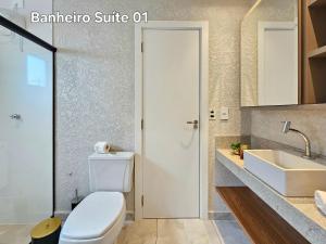 une salle de bain avec des toilettes blanches et un lavabo dans l'établissement Centro 2 quartos 2 banheiros - alto padrao novo, à Foz do Iguaçu 37 autres photos