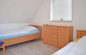 a bedroom with two beds and a dresser and a window at Ferienwohnung Feldberger in Conow