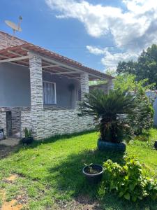 a house with two palm trees in a yard at Casa temporada Guarapari in Guarapari