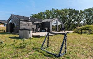 una casa con una valla en el patio en Cozy Home In Ejstrupholm, en Ejstrup