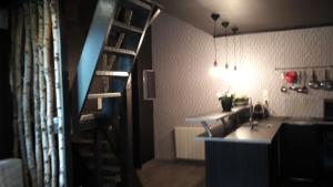 Habitación con escalera, lavabo y cocina. en Cottage du Lac Studio, en Nivezé