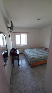 a bedroom with a bed and a desk and a window at Departamento Amplio Familiar in Ushuaia