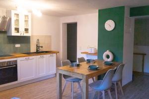 a kitchen with a table and chairs and a clock on the wall at Ferienwohnung "Wasser" mit Sauna im Ferienhaus am Waldbach in Kirchzell