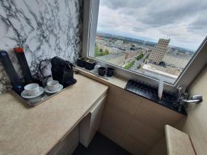 a kitchen with a window and a counter with cups at Amazing View 19 floor! Metro Świętokrzyska in Warsaw +13 photos