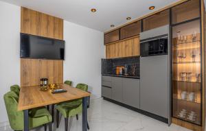 a kitchen with a wooden table and a refrigerator at Beautiful Apartment In Crikvenica in Crikvenica