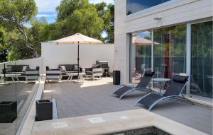 a patio with chairs and a table and an umbrella at Luxurious Apartment In Postira in Postira
