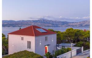 a white house with a red roof with a view of the water at Luxurious Apartment In Postira in Postira