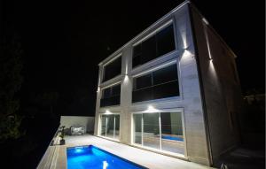 a house with a swimming pool at night at Luxurious Apartment In Postira in Postira