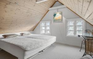una camera da letto con un grande letto bianco in una soffitta di Pet Friendly Home In Karby a Karby Altre 17 foto