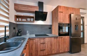 a kitchen with wooden cabinets and a stainless steel refrigerator at Stunning Home In Vinogradi Ludbreski in Vinogradi Ludbreški