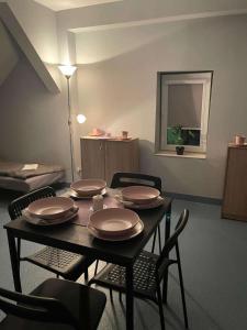 a dining room table with plates on it with chairs at Wiejskie Kwatery Dolina Baryczy in Ujeździec Mały