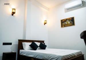 Un dormitorio con una cama con sábanas y almohadas blancas. en Belle villa, en Mirissa