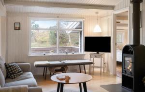 a living room with a couch a table and a tv at Gorgeous Home In Sjællands Odde in Yderby