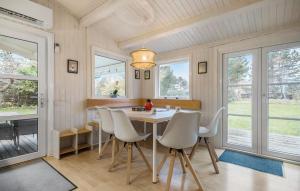 a dining room with a table and chairs and windows at Gorgeous Home In Sjællands Odde in Yderby
