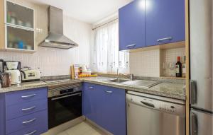 a kitchen with blue cabinets and a sink at Cozy Apartment In Villajoyosa With Wifi in Villajoyosa
