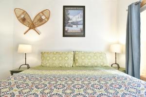 a bedroom with a bed and two lamps and a poster at La Riva Del Lago Condo: Downtown, Close to Everything! in Dillon