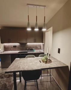 a large kitchen with a table and chairs in it at Ghini Venes 2 Καλώς ήλθες in Tríkala