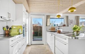 a kitchen with white cabinets and a door to a yard at Stunning Home In Haderslev With Wifi in Haderslev