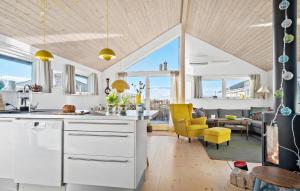 a kitchen with white cabinets and yellow chairs and a living room at Stunning Home In Haderslev With Wifi in Haderslev +15 photos