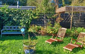 two rocking chairs and a bench in a yard at Nice Home In Warmenhuizen With Wifi in Warmenhuizen +10 photos