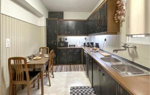 a kitchen with wooden cabinets and a table with chairs at Nice Apartment In Anavissos With Wifi in Anavissos