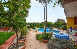 a courtyard with a pool with plants and a table at 2 Bedroom Nice Apartment In Trecastagni in Trecastagni