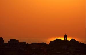 a silhouette of a city with a clock tower at sunset at Nice Home In Ragusa With Wifi in Ragusa +8 photos