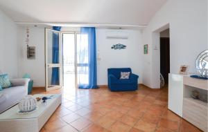 a living room with a couch and a blue chair at 2 Bedroom Amazing Home In Triscina in Triscina