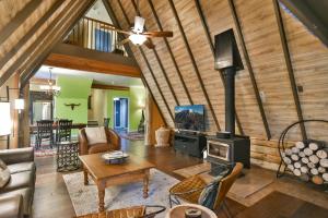 a living room with a fireplace and a stove at Spruce Creek Lodge: Classic A-Frame Mountain Retreat in Blue River