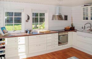 a kitchen with white cabinets and a sink at Amazing Home In Fitjar With Wifi in Fitjar