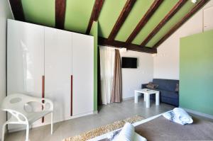 a living room with green walls and white cabinets at House Sweet Dreams in Pučišća