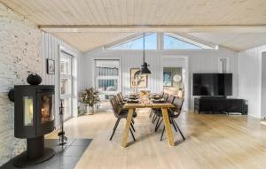 a living room with a table and a fireplace at 3 Bedroom Cozy Home In Nibe in Nibe