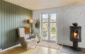 a living room with a chair and a wood stove at 3 Bedroom Cozy Home In Nibe in Nibe