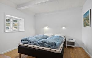 a bed in a white room with a window at 2 Bedroom Amazing Home In Blåvand in Blåvand