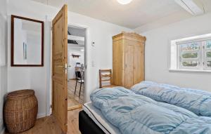 a room with three beds in a room with a door at 2 Bedroom Amazing Home In Blåvand in Blåvand +20 photos