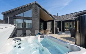 a hot tub in the backyard of a house at Lovely Home In Vejers Strand With Sauna in Vejers Strand