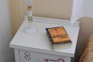 a white bedside table with a book on it at Hotel Che Mar in Necochea