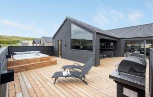 a deck with a hot tub on a house at Amazing Home In Hvide Sande With Sauna in Bjerregård +31 photos