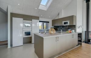 a kitchen with white and gray cabinets and a sink at Amazing Home In Hvide Sande With Sauna in Bjerregård
