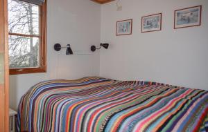 a bedroom with a colorful striped blanket on a bed at Lovely Home In Backaryd With Lake View in Backaryd +15 photos