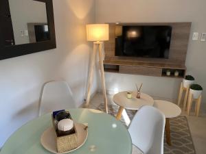 a living room with a table and chairs and a television at Micro ensueño in Godoy Cruz